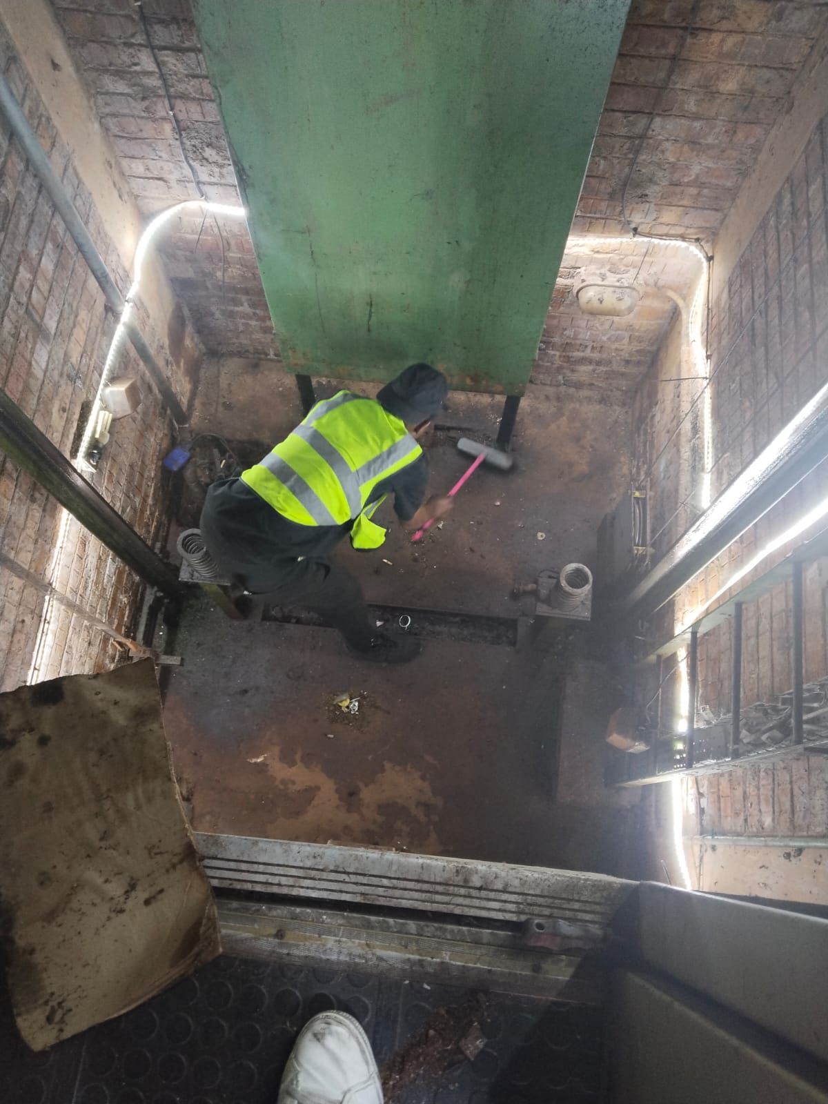 Technician working inside a lift shaft for maintenance preparation